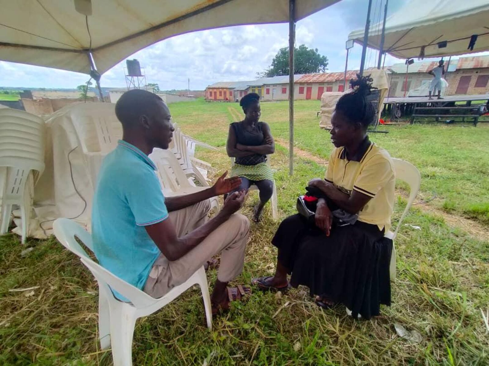 People in conversation under a tent