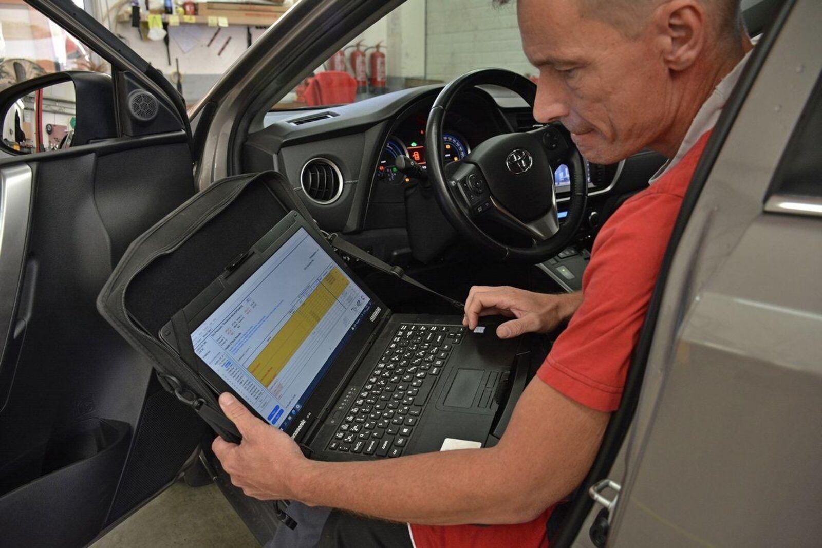 Vehicle diagnostics on a laptop inside a car