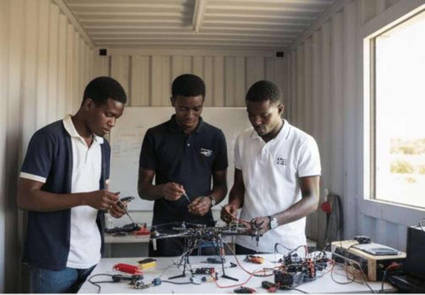 Three young men practising electronics together